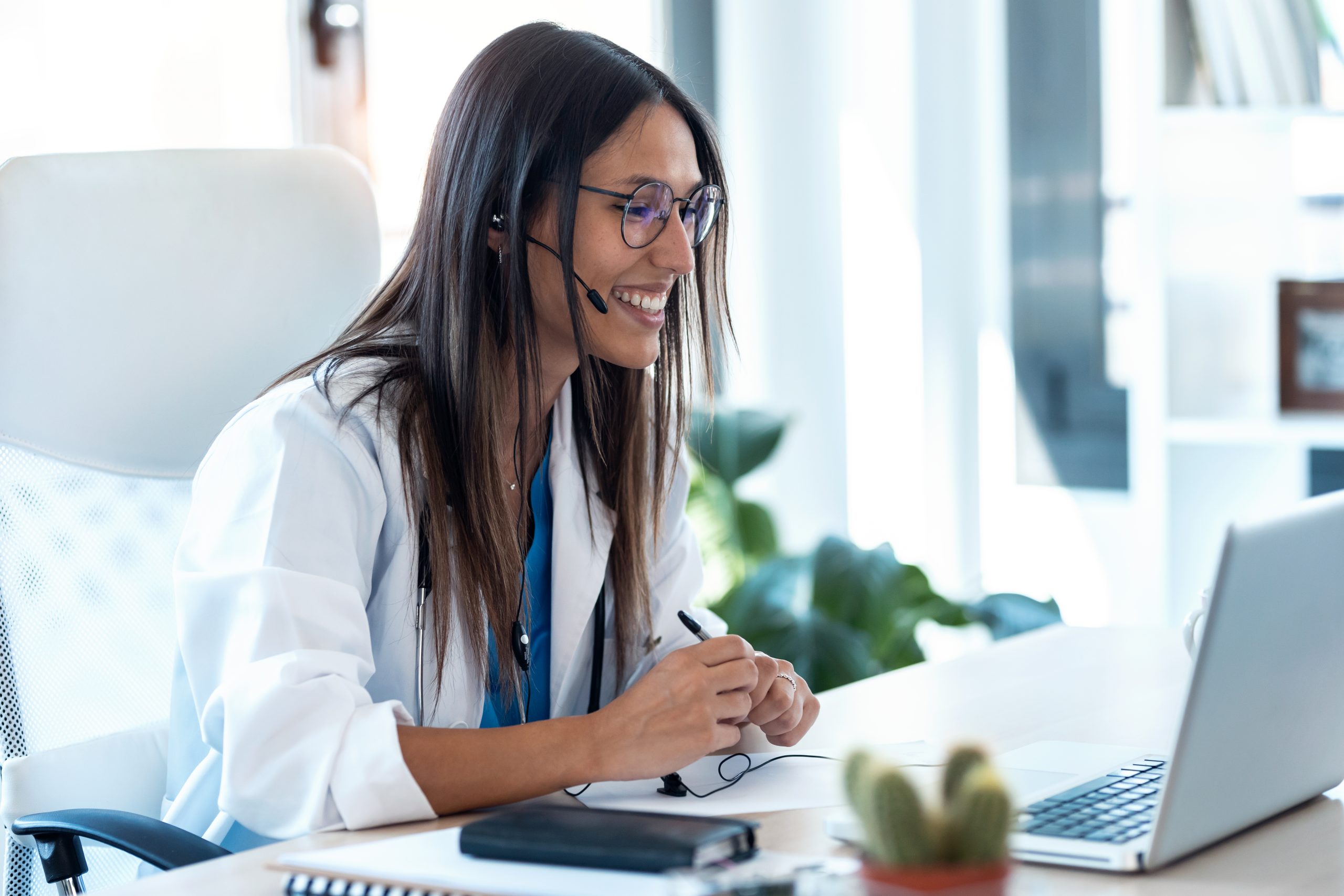 Female doctor talking with colleagues through a video call with