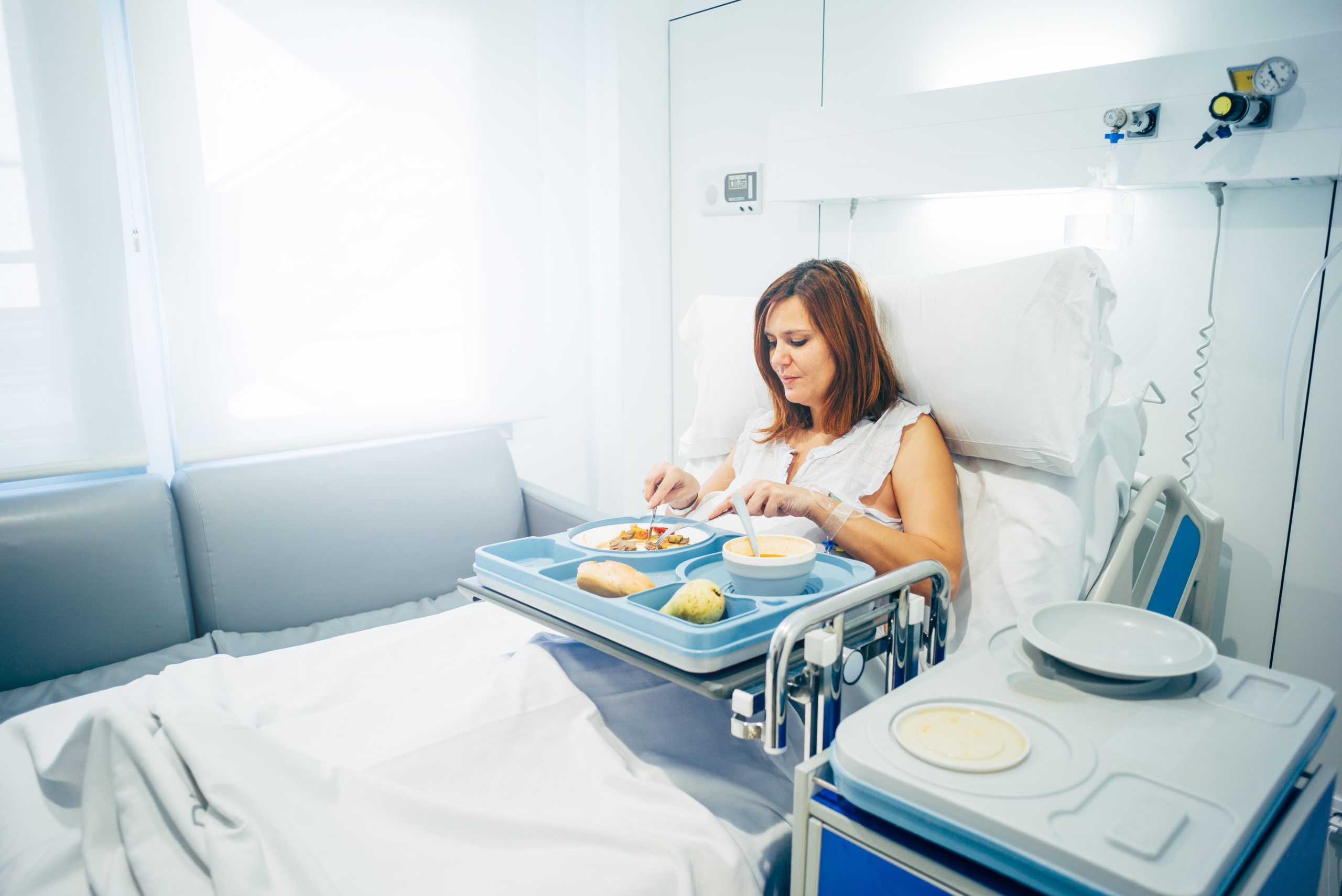 Sick woman eating in the hospital.